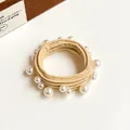 Elastic beige hair tie with assorted white pearls shown on a light background - Beige
