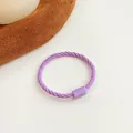 Elastic purple twisted hair tie with matching rectangular buckle on warm felt surface - Purple