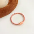 Pink orange spiral kids hair tie with grooved texture and matching rectangular connector - Orange