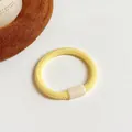 Élastique à cheveux jaune clair avec perle rectangulaire crème sur fond blanc - Jaune