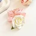 Chouchou en satin rose avec une fleur de camélia en tissu blanc et feuille verte - Rose bourgeon