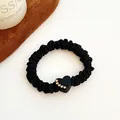 Elastic black scrunchie featuring a heart charm with inlaid golden rhinestones - Heart - Black