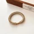 Elastic braided hair tie in golden brown finish with shimmering metallic thread - Khaki
