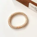 Elastisch geweven haarelastiekje in koffiebruin met een duurzame schroeftextuur - Beige