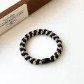 Elastisches geflochtenes Haargummi in Schwarz und Gold mit polierter ovaler Zierperle - Schwarz