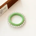 Élastique à cheveux vert clair avec perles blanches sur un fond doux et soyeux - Vert