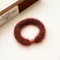 Thick plush elastic hair tie in brown-red faux fur with smooth cylindrical clasp - Rust red