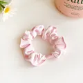 Pink fabric scrunchie with subtle floral prints and a high-elasticity pleated design - Pink