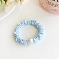 Light blue elastic hair scrunchie with a large pearl bead and pleated fabric texture - Blue