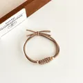 Minimalistische koffiebruine gevlochten haarelastiek met gouden kralen en knoop - Khaki