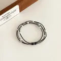 Elastisches Perlen-Haargummi mit Goldfaden und weißen Perlen, auch als Armband nutzbar - Schwarz
