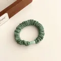 Chouchou en velours vert avec boucle vert clair sur fond minimaliste moderne - Vert