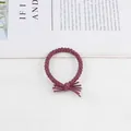 Detailed view of hand-braided dark purple elastic hair tie with stylish tassel knot design - Dusty Pink