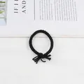 Detail of hand-woven black twisted braided hair tie with a decorative tassel knot - Black