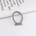 Detail van gedraaid grijs en roze gevlochten haarelastiekje met een kwastje als knoop - Oudroze