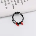 Dettaglio di elastici per capelli 3-in-1 con perline rosse su sfondo rivista minimalista - Perline Rosse Piccole