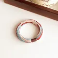 Blue and orange striped plush hair tie with textured chenille fabric and brown clasp - Red