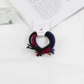 Set di 3 elastici per capelli intrecciati in nero, rosso e blu su cartoncino ciliegia - Colori Vivaci