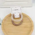 Set aus zwei Spiral-Telefonkabel-Haargummis in klar und braun auf Sternen-Karte - Grau/Weiß
