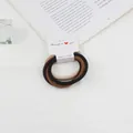 Close-up of elastic hair ties in brown and beige colors with a branded paper card - Multicolor