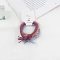 Dettaglio di elastici per capelli intrecciati rosa e blu con confezione in cartoncino - Colori Pastello