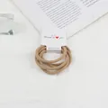 Close-up of four khaki elastic hair ties on a white display card with soft lighting - Khaki