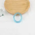 Elastisches blaues transparentes Spiralhaargummi auf Holztablett mit Leinenhintergrund - Blau