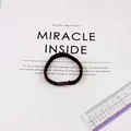 Macro shot of dark brown high-elastic braided hair tie with cylindrical connector and ruler - Dark Coffee