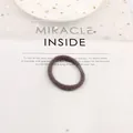 Close-up of soft brown plush hair scrunchie with smooth buckle detail on star mesh background - Gray