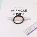 Elastic brown braided hair tie with a 5cm diameter on a clean aesthetic background - Brown