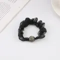 Detail of black organza scrunchie featuring a premium rhinestone-encrusted bead ornament - Black
