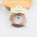 Brown elastic hair tie set in cream packaging on a wooden tray with a minimalist style - Khaki