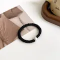 Minimalist black pleated hair tie with a single round white pearl accent for daily styling - Black