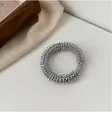 Détail d'un élastique spirale argenté sur un fond esthétique à la texture raffinée - Gris Argent