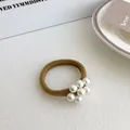 Braunes hochelastisches Haargummi mit weißen Perlen im minimalistischen Design - Kurkuma