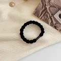 Black twisted elastic hair tie on fabric background, thick and durable ponytail holder - Black