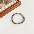 Contrast beige and black elastic hair tie with woven texture and a brown buckle - Khaki
