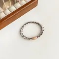 Elastic braided hair tie in beige and black with an oval resin buckle fastener - Beige