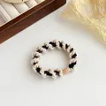 Coletero de punto en espiral elástico en negro y beige con un cierre de plástico duradero - Negro Arroz