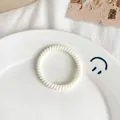 Elastic white spiral telephone wire hair tie on a minimalist ceramic plate - Matte-Milk White