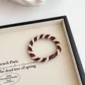 Elastische spiraalvormige haarelastiek in donkerbruin en beige met geribbelde textuur - Donker Koffie
