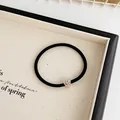 Elastic black hair tie with a sparkling rhinestone heart pendant in a gold setting - Black
