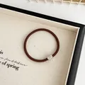 Brown elastic hair tie with sparkling rhinestone heart pendant in a stylish display - Brown