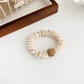 Velvet scrunchie in beige cream with a sparkling golden rhinestone sphere detail - Beige