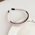 Serre-tête en satin rose avec dents antidérapantes noires sur une assiette blanche - Style Antidérapant Denté / Rose