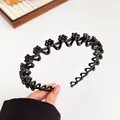 Golvende zwarte antislip hoofdband met matte bloemaccenten voor dameskapsels - Zwart