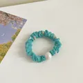 Muntgroene bloemen scrunchie met grote witte parel op een witte achtergrond - Blauw
