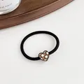 Elastic hair tie featuring a brown checkered heart charm with black metal edging - Black