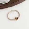 Elastic beige hair tie with heart-shaped brown checkerboard charm in golden frame - Beige