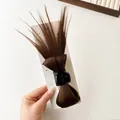 Chestnut brown hair claw clip with messy bun hairpiece on white display card - Tan